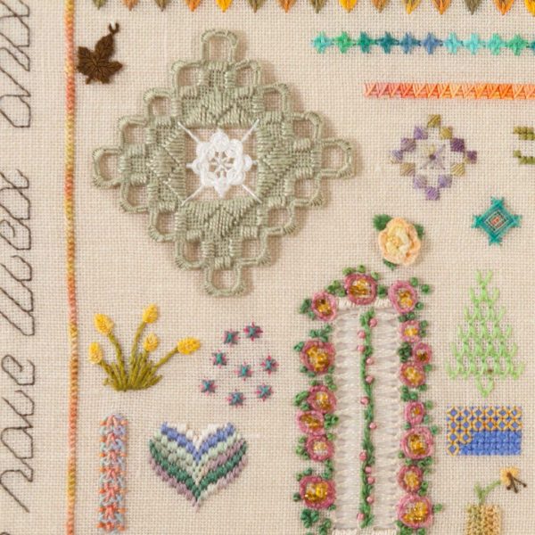 Photo of an embroidery with a variety of motifs and flowers stitched on evenweave fabric.