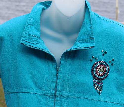 photo of a blue top with w beaded design on the shoulder