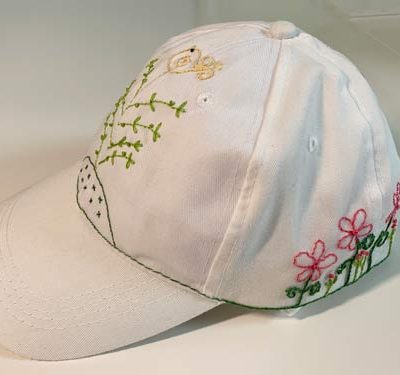 photo of a baseball style cap with embroidered flowers on it