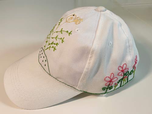 photo of a baseball style cap with embroidered flowers on it