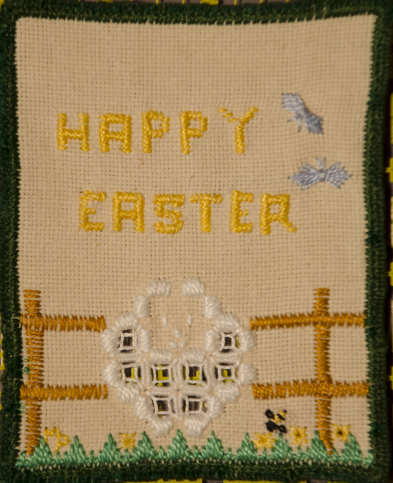 The front of an embroidered Easter card with a sheep and Happy Easter greeting.