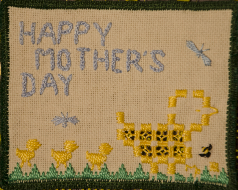 An embroidered card with a duck and ducklings and a Happy Mother's Day sentiment.