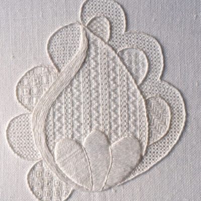 photo of an embroidered a flower bud formed in white textured embroidery
