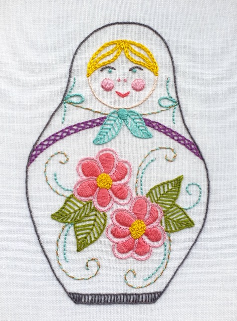 photo of an embroidered Matryoshka doll with flowers on her body