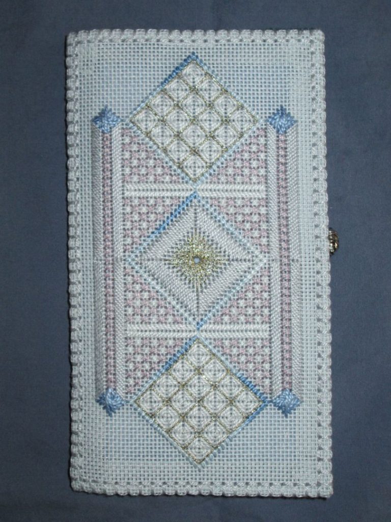 photo of a tall, narrow embroidery with three squares in the middle and tall narrow bands on each side