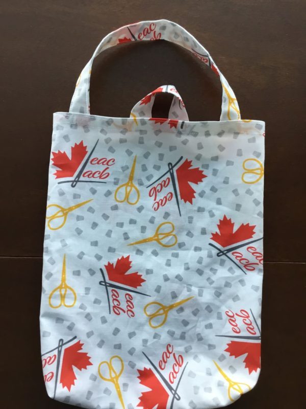 photo of a fabric bag with a pull-through handle made with EAC/ACB logo fabric