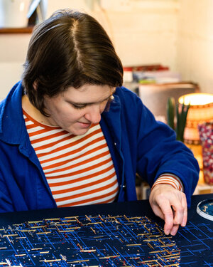 photo of Hanny Newton working on embroidery