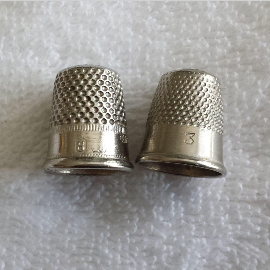 a photo of two silver thimbles