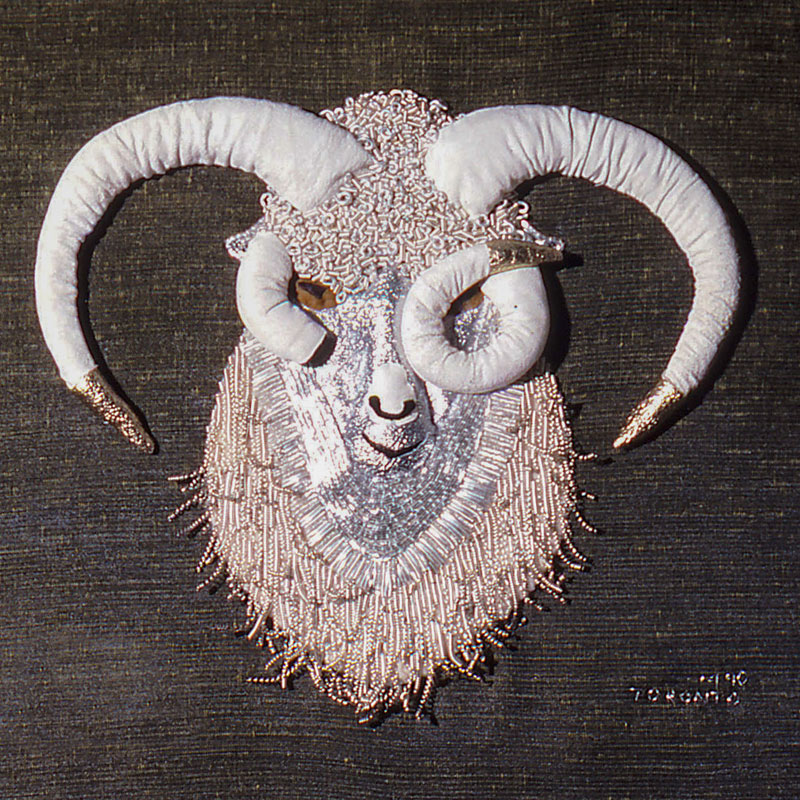 Photo of a dimensional embroidery of a ram's head with silk and metal threads.