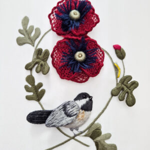 Two 3-d red poppies with navy and white centers, stitched above a 3-d chickadee. The chickadee is stitched in white, dark grey and yellow, and sits at the crossing of two stems. One stem has 3 leaves, while the other stem has 2 leaves, a red bud and a yellow bug.